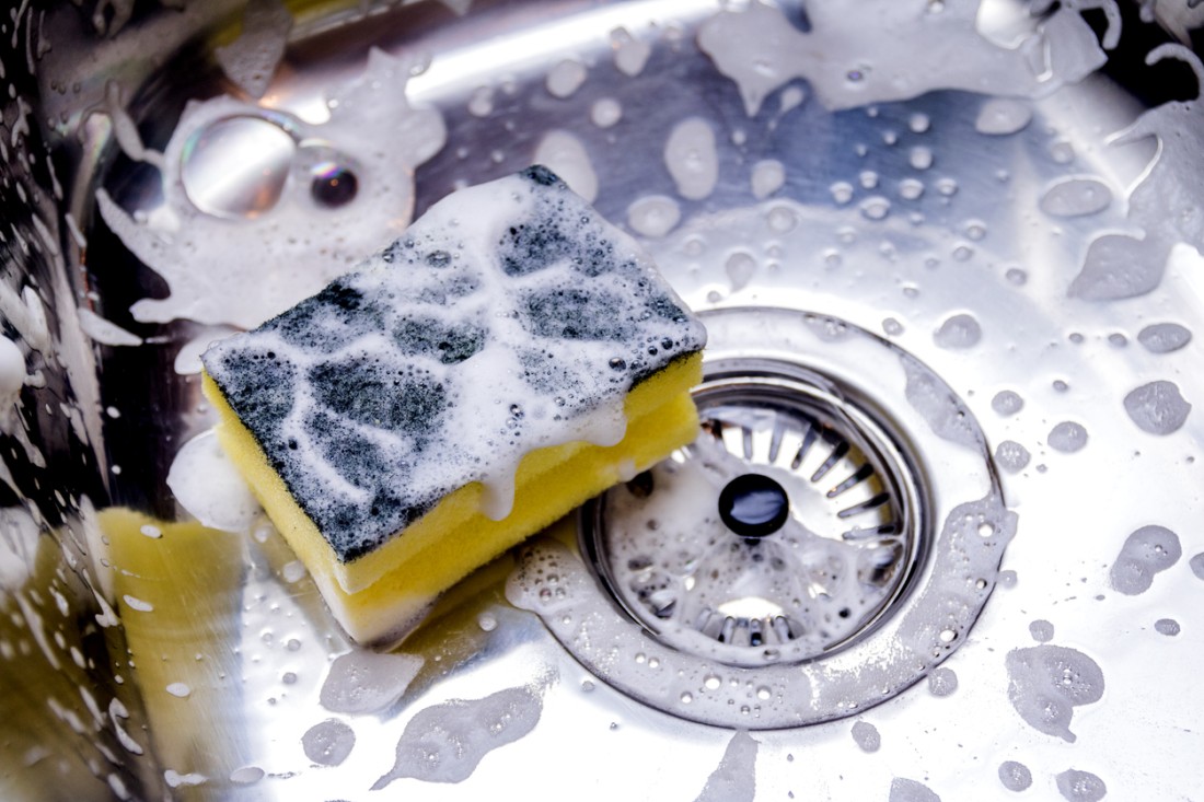 A photo of sponge in a sink full of bubbles