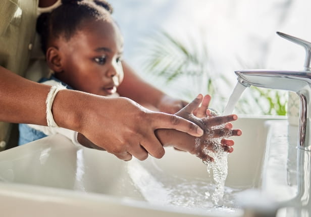 A photo of a child washing her hands